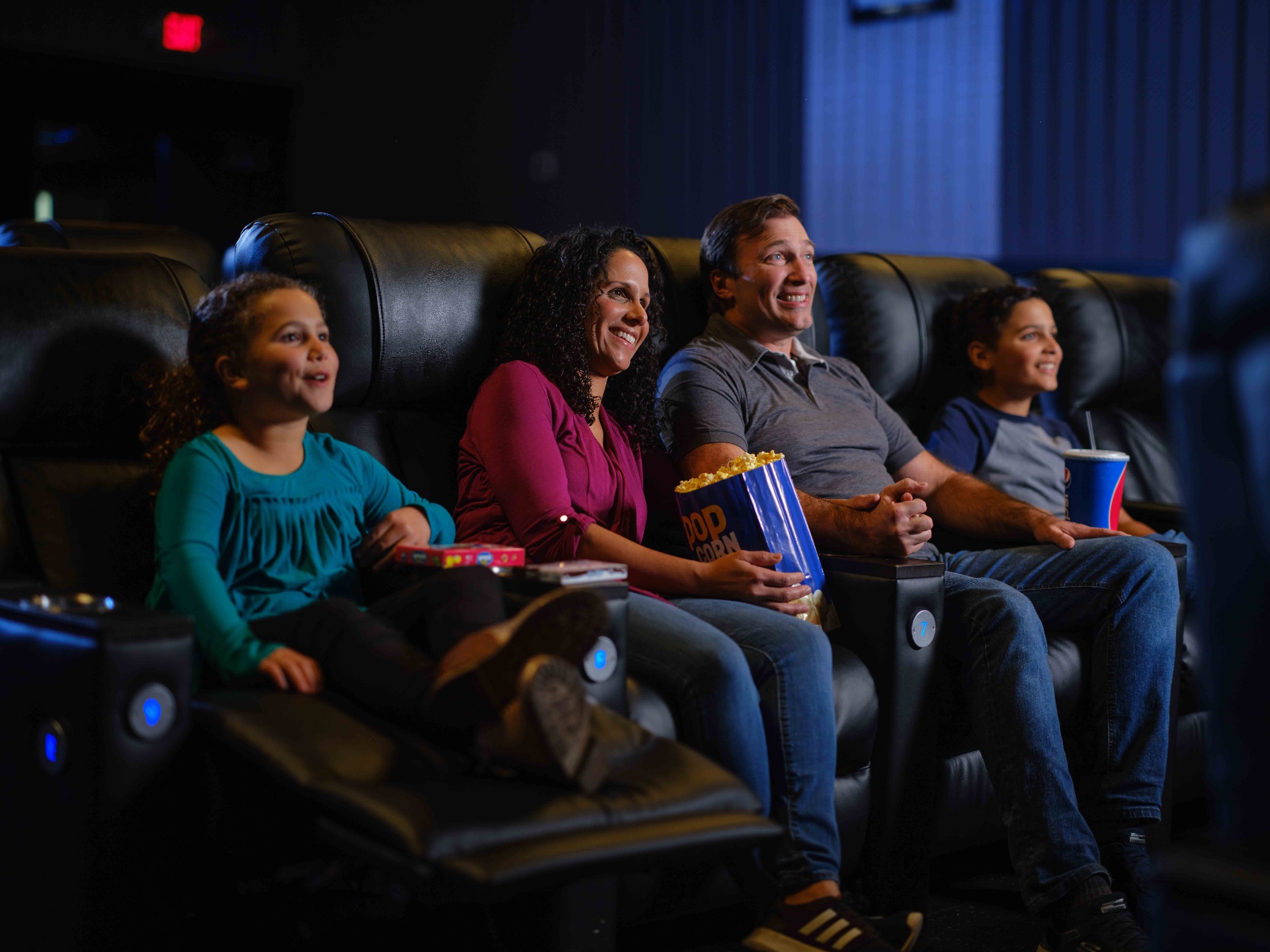 Guests enjoying a movie in premium recliner seats